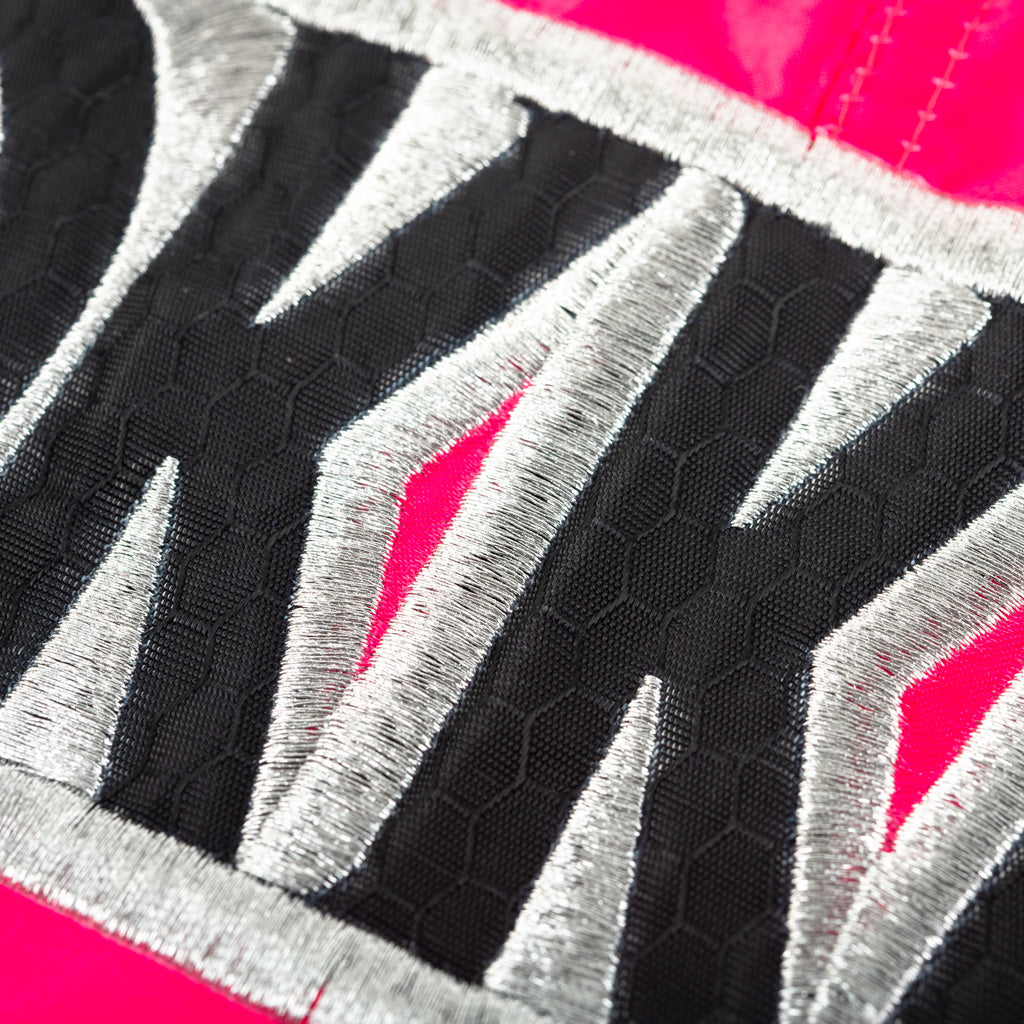 Close-up of a textured fabric with YOKKAO geometric patterns on a pink background