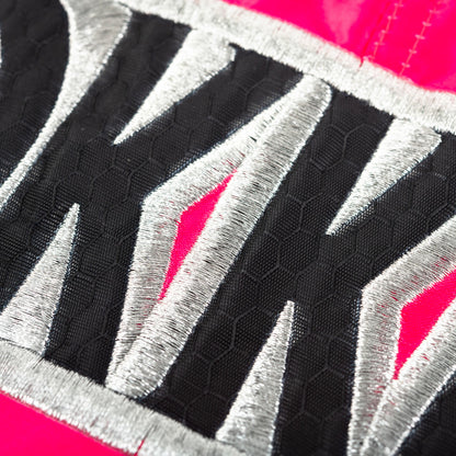 Close-up of a textured fabric with YOKKAO geometric patterns on a pink background