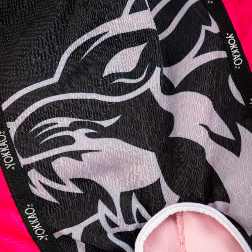 Close-up of a black and white patterned product with 'Yokkao' branding on a pink background.