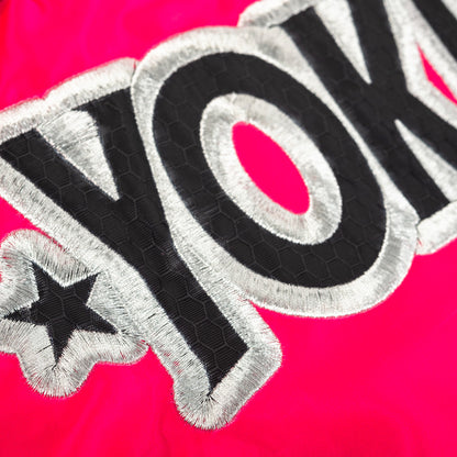 Embroidered patch with 'YOKKAO' text on a pink background