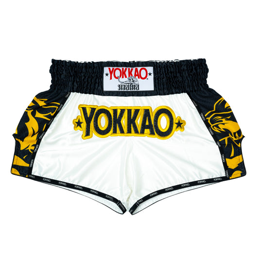 White Muay Thai shorts with black and yellow designs and 'Yokkao' branding